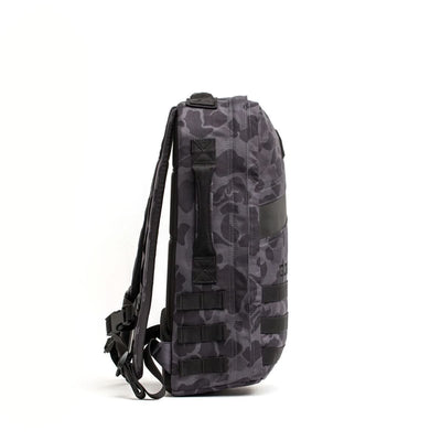 Side view of the Rucker 4.0, a gray camouflage rucksack with black straps and buckles, perfect for rucking, shown against a white background.
