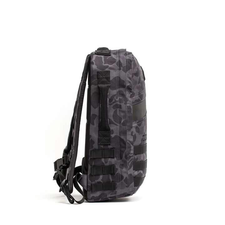 Side view of the Rucker 4.0, a gray camouflage rucksack with black straps and buckles, perfect for rucking, shown against a white background.