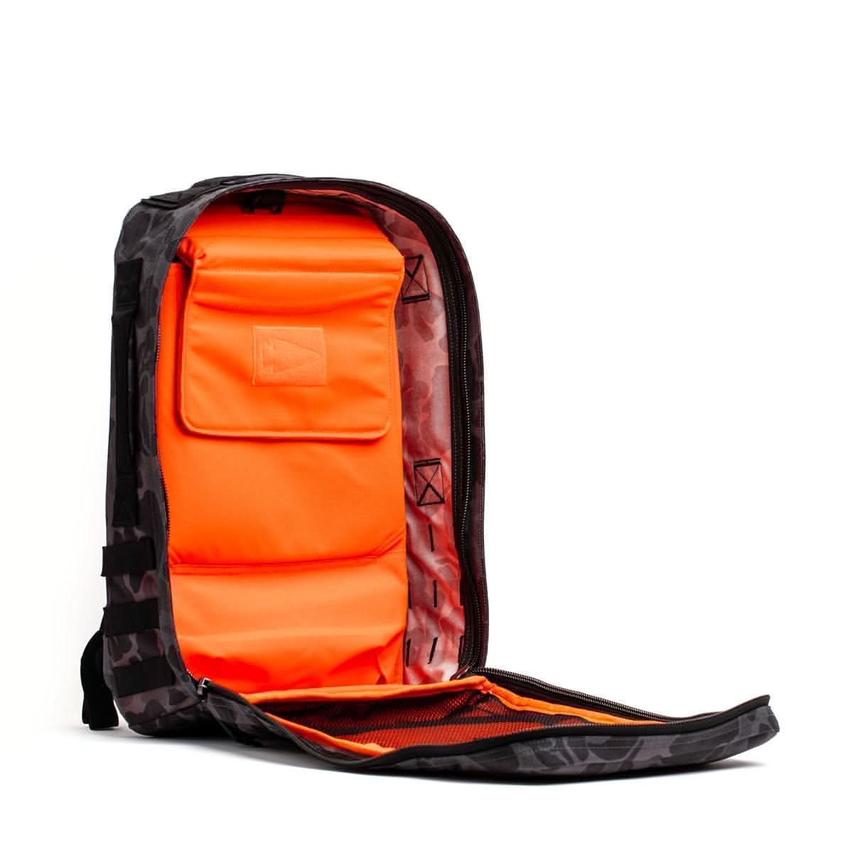 The Rucker 4.0 is a black backpack with a bright orange interior, shown open to reveal multiple inner pockets and compartments—perfect for rucking or daily use.