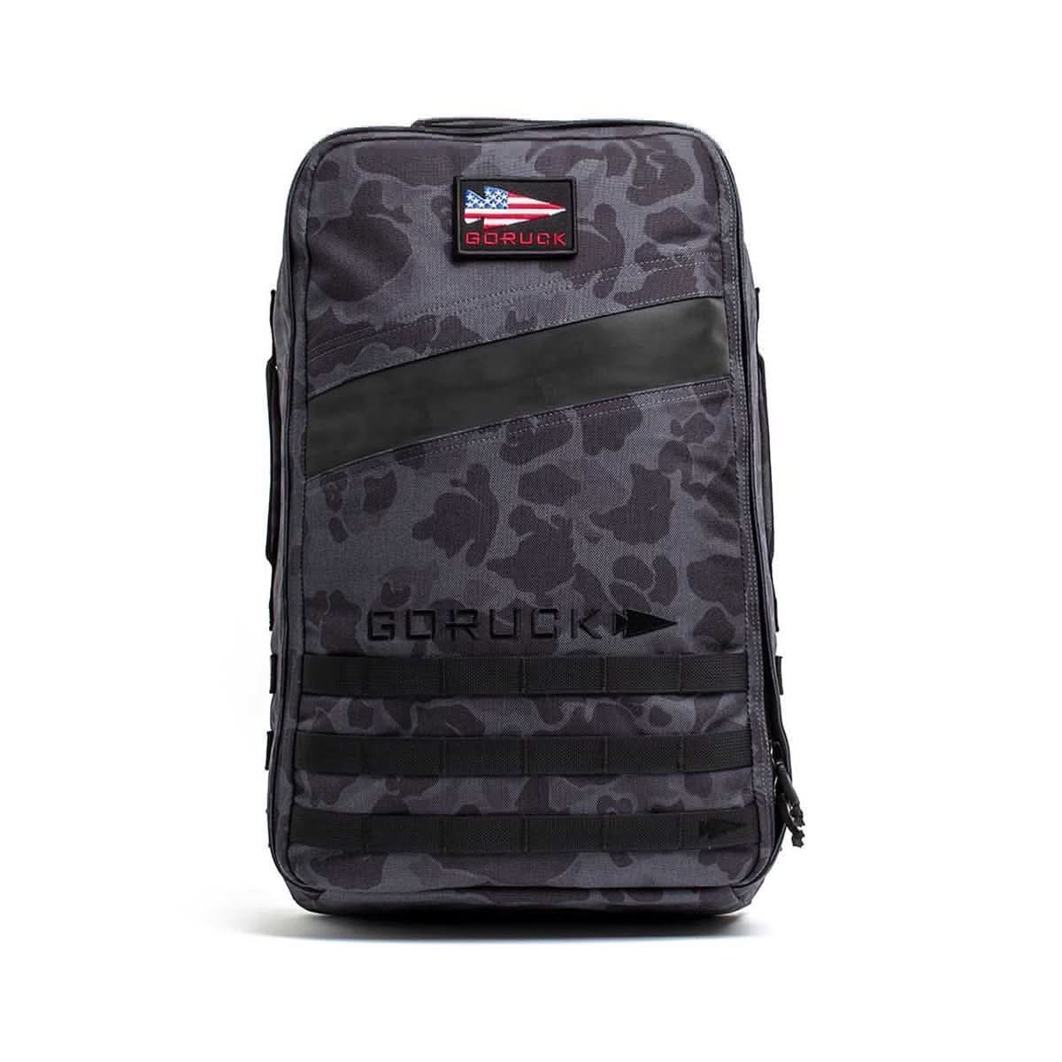 The Rucker 4.0 is a gray camouflage backpack with black accents, an American flag patch, and "GORUCK" logo on the front—built for rucking and securely holds your Ruck Plates.