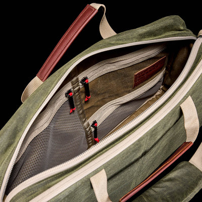 Open green Shoulder Bag - Waxed Canvas with tan zippers, mesh interior pockets, and brown leather accents, featuring a Martexin Wax finish, photographed from above.