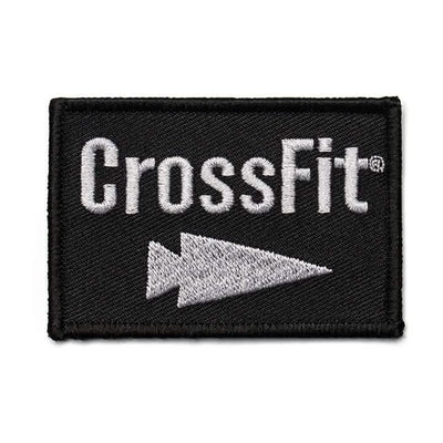 The Patch - GORUCK x CrossFit by GORUCK-DEMO showcases a finely embroidered CrossFit logo with sharp white lettering and an arrow icon set against a stylish black backdrop, ideal for enhancing your GORUCK equipment.