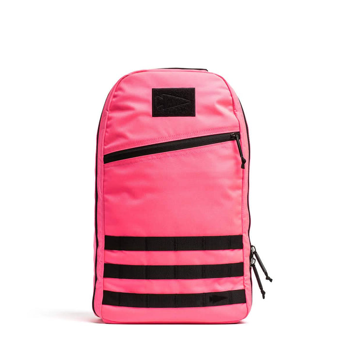 The Bullet Ruck - Classic - Hot Pink is a vibrant pink Cordura daypack featuring a front zip pocket and three black horizontal straps near the base.