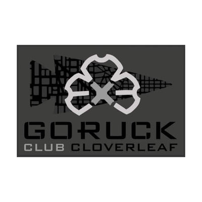 Patch for GORUCK's Ruck Club Cloverleaf showcasing a stylized cloverleaf design in gray on a dark background adorned with a grid pattern and arrow motif, representing the unity of the ruck club's community fitness.