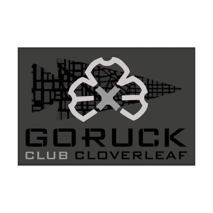 Patch for GORUCK's Ruck Club Cloverleaf showcasing a stylized cloverleaf design in gray on a dark background adorned with a grid pattern and arrow motif, representing the unity of the ruck club's community fitness.