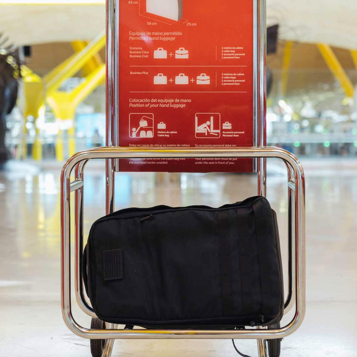 A GR1 USA - Cordura (The Original Ruck) black bag from GORUCK, crafted with the precision of American manufacturing, sits in a luggage sizer at the airport, seamlessly verifying its compliance with hand luggage size restrictions.