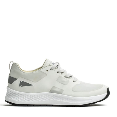 Introducing the GORUCK Men's Rough Runner in Light Grey and Dark Grey: This athletic shoe boasts a sleek, performance-enhancing design with gradient density. It features light gray accents on the heel adorned with an arrow-like graphic, while the textured white midsole seamlessly pairs with a black outer sole. Gray laces are threaded through ingeniously designed channels for added style and functionality.