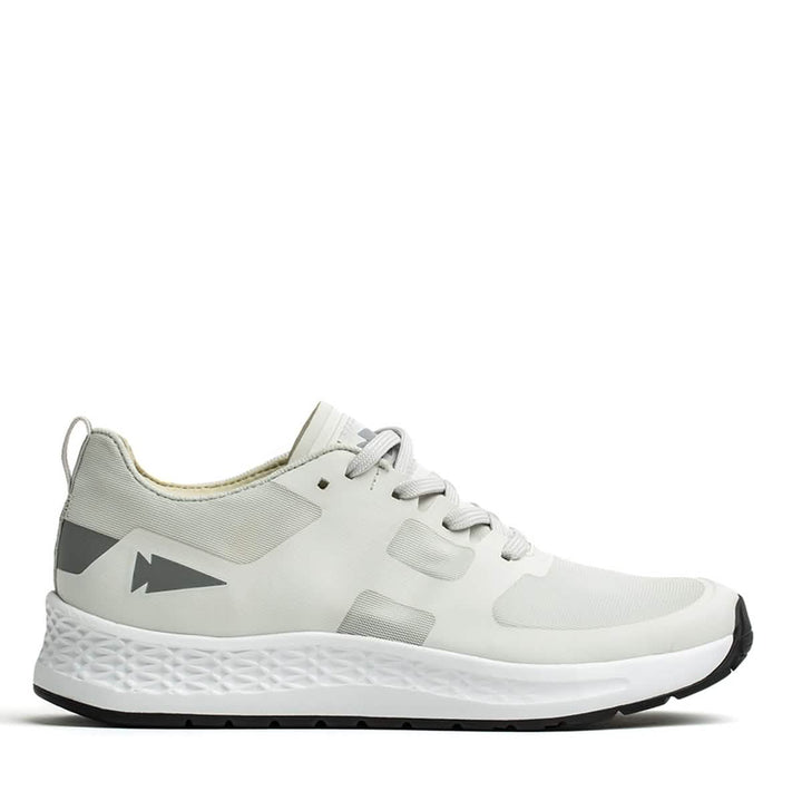 Introducing the GORUCK Men's Rough Runner in Light Grey and Dark Grey: This athletic shoe boasts a sleek, performance-enhancing design with gradient density. It features light gray accents on the heel adorned with an arrow-like graphic, while the textured white midsole seamlessly pairs with a black outer sole. Gray laces are threaded through ingeniously designed channels for added style and functionality.