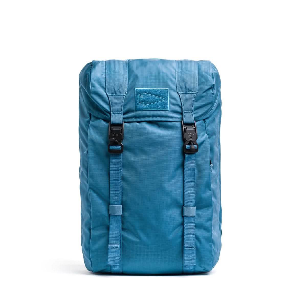 Introducing the GORUCK M23, a contemporary rucksack meticulously crafted from robust Ripstop ROBIC® fabric. This backpack in Seaspray and Speed Tan features a sleek rectangular design with a top flap closure secured by two black buckles. Its two adjustable front straps ensure optimal organization, making it perfect for outdoor adventures.
