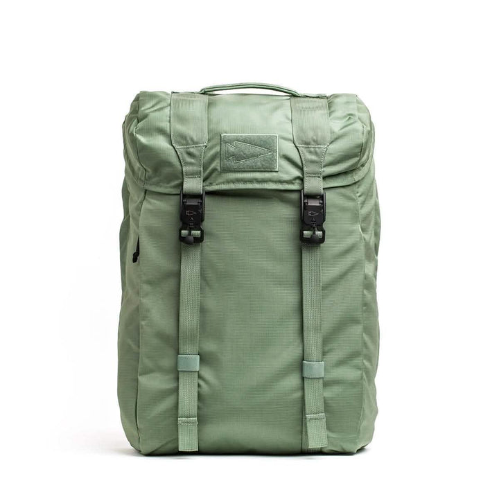 The GORUCK M23 - Ripstop ROBIC® in Seaspray and Speed Tan is a textured rucksack featuring a top flap with two black buckles, a carrying handle, and adjustable straps. Made from durable materials, it seems lightweight and functional for everyday use or travel.