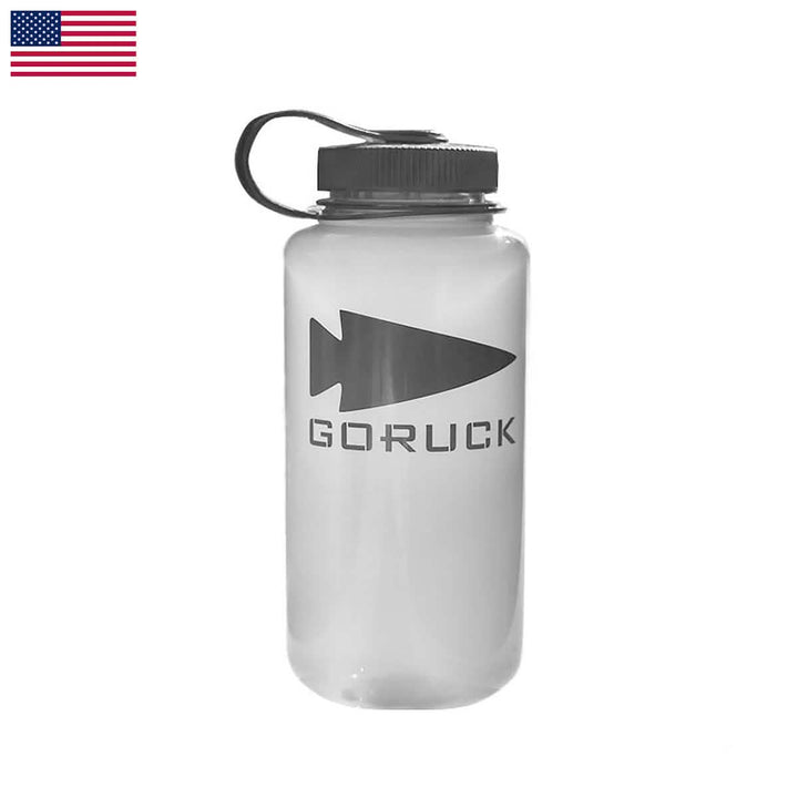 A sturdy Nalgene Water Bottle (32oz) - GORUCK Spearhead with a black cap and handle, showcases an arrowhead logo alongside the word GORUCK in black. It features an American flag on the top left corner on a white background, ideal for adventure enthusiasts.