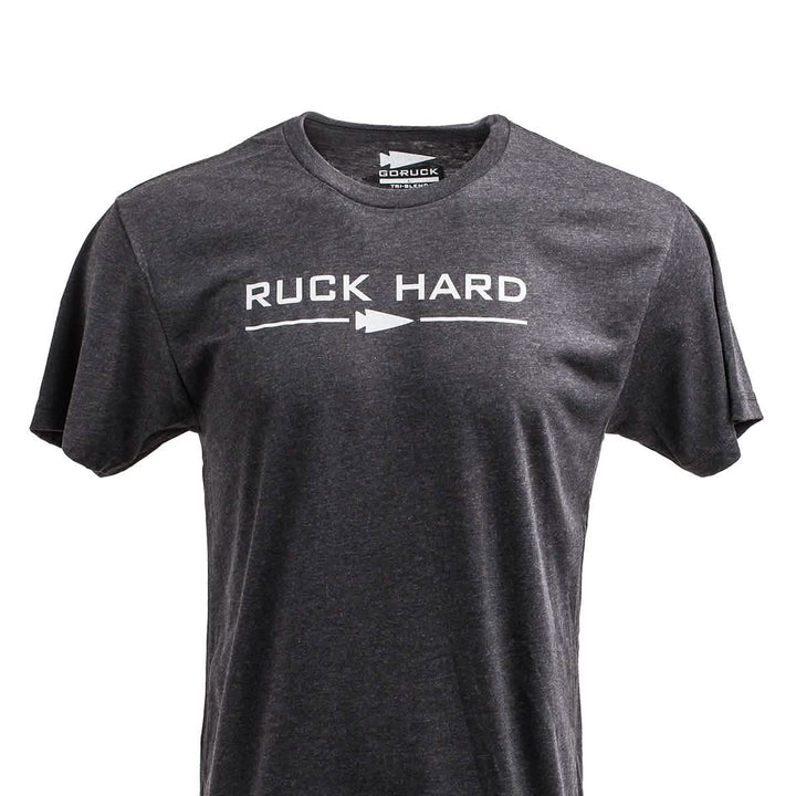 The Ruck Hard Tee - Tri-Blend is a gray T-shirt with "RUCK HARD" and an arrow design on the front, ideal for fitness or ruck training.