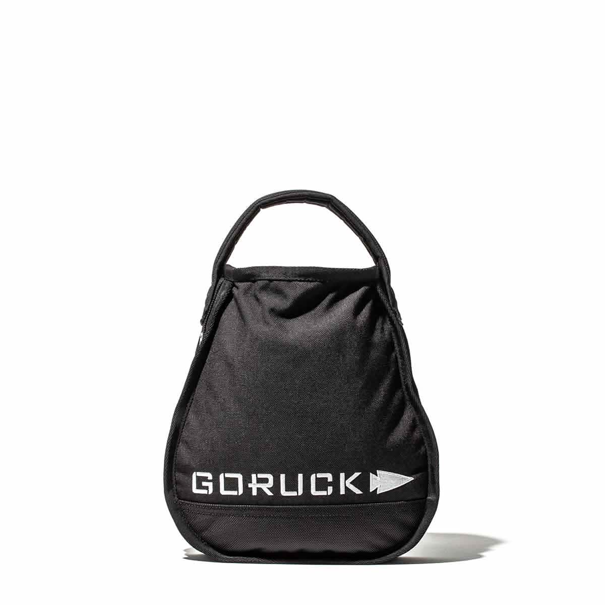 A sand kettlebell from GORUCK, showcasing the brand's name and an arrow symbol, echoes its enduring design qualities. Set against a plain white background, it embodies strength and style.