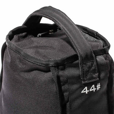 A close-up of a textured black Sand Kettlebell by GORUCK reveals reinforced handles and the number 4.4# printed in white on its side, highlighting its endurance design ideal for versatile workouts on the go.