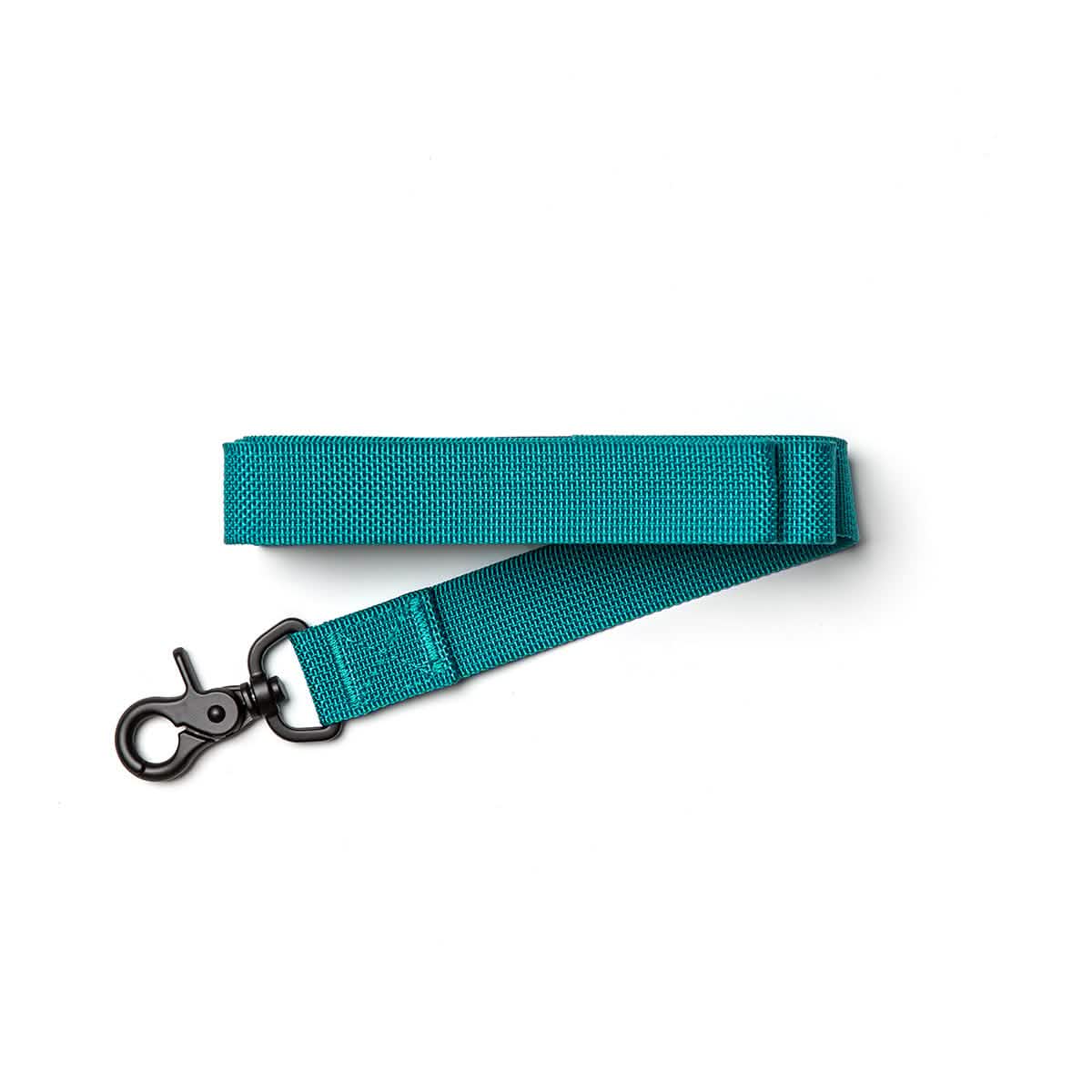 A teal Small Dog Leash by GORUCK, featuring a secure metal clip, is coiled neatly against a white background and crafted from durable military-grade nylon.