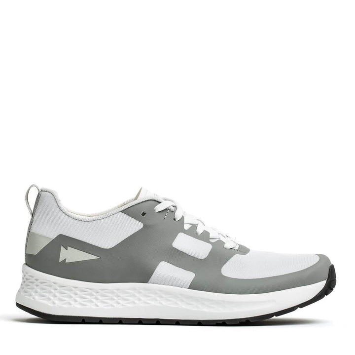 The Women's Rough Runner - White + Speed Grey athletic shoe from GORUCK features a sleek white and gray design with a textured sole for enhanced grip and a Gradient Density EVA Midsole for extra support. Complete with white shoelaces and adorned with a small arrow logo on the side, this shoe embodies a lightweight, modern aesthetic ideal for active endeavors.